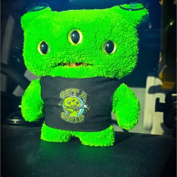 A small green plush toy that rides on the van dashboard
